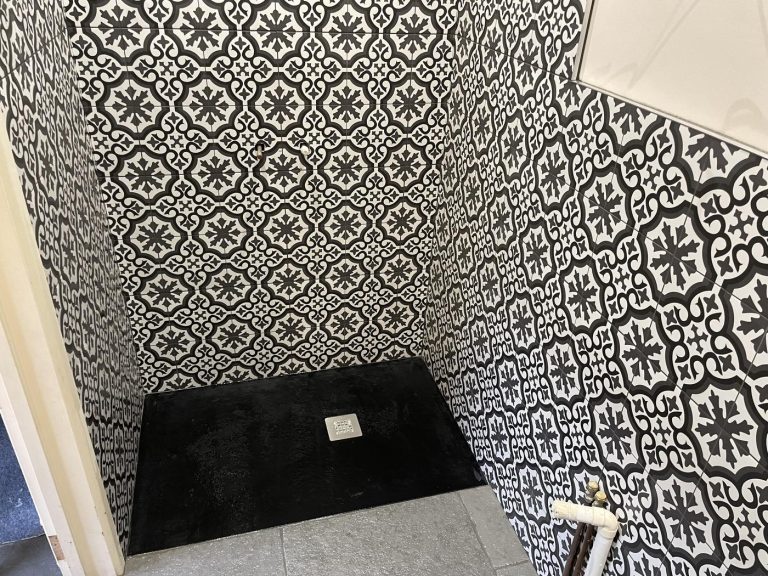 Completed bathroom showing decorative shower tiles, black shower tray and Cathedral Grey limestone floor
