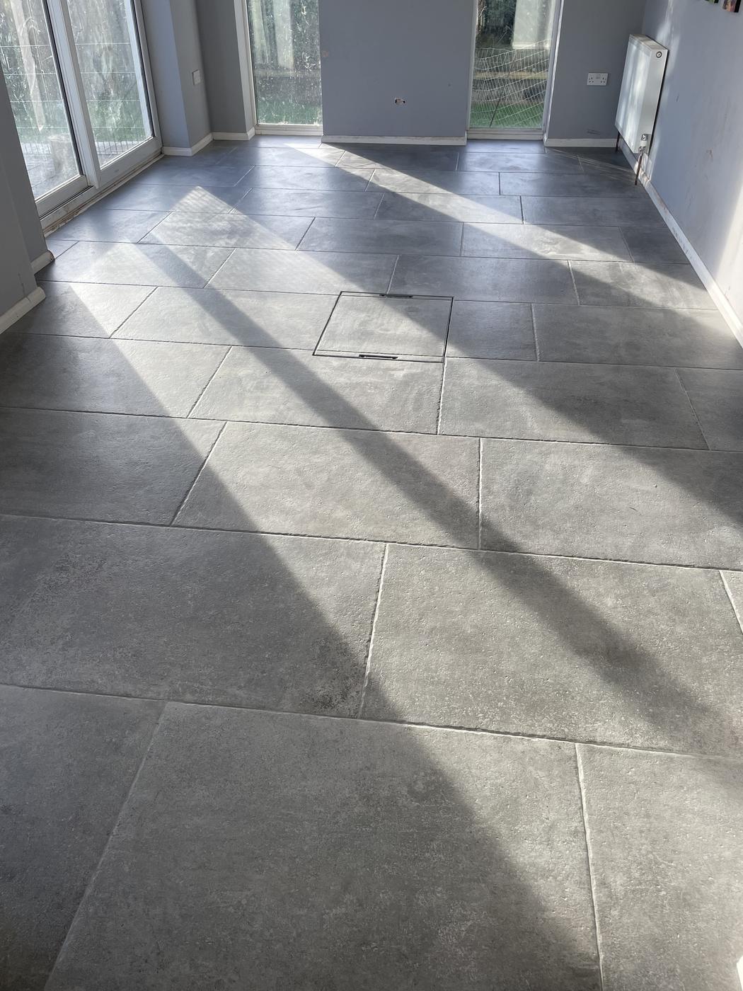 Large-format grey porcelain tiles across an open-plan room in Dorset