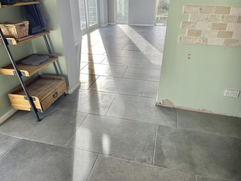 Large porcelain floor tiles installed across open plan room and kitchen in Shaftesbury home