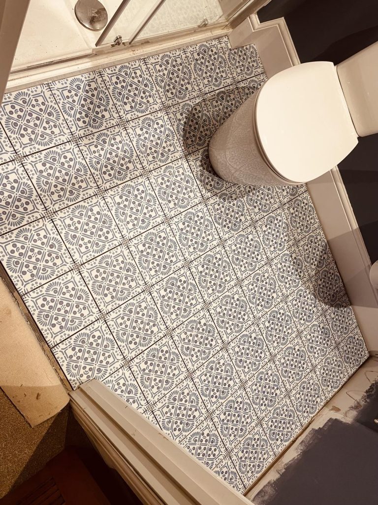 Decorative patterned bathroom floor tiles installed in small bathroom renovation